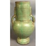 AN ANTIQUE PERSIAN GREEN GLAZED POTTERY VASE Of plain form with twin handles. (approx 35cm)