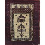 A MIDDLE EASTERN PRAYER RUG Geometric design on a cream field, contained within burgundy running