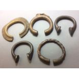 A COLLECTION OF FIVE SMALL AFRICAN MANILLA BRONZE SLAVE BANGLES Elliptical form with engraved
