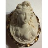 A 19TH CENTURY YELLOW METAL AND LAVA CAMEO BROOCH Classical female bust carved in high relief in