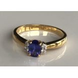AN 18CT GOLD, OVAL CUT TANZANITE AND DIAMOND RING.