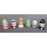 ROYAL WORCESTER, A SET OF SIX PORCELAIN CANDLE SNUFFERS Modelled as Punch and Judy characters,