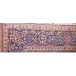 A PERSIAN DESIGN WOOLLEN RUG The madder field with pendant medallion and floral decoration within