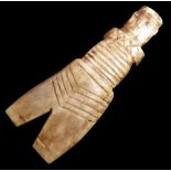 AN INUIT CARVED WHALE BONE SCRIMSHAW A figure in geometric carved attire. (approx 19cm)