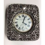 A VICTORIAN SILVER AND CROCODILE SKIN TRAVEL CLOCK The pierced silver cladding, hallmarked