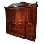 A 19TH CENTURY MAHOGANY BREAKFRONT TRIPLE WARDROBE The classical pediment on stepped cornice,