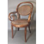 AN EARLY 20TH CENTURY BENTWOOD CHILD'S CHAIR With rattan back and seat raised on splayed legs.