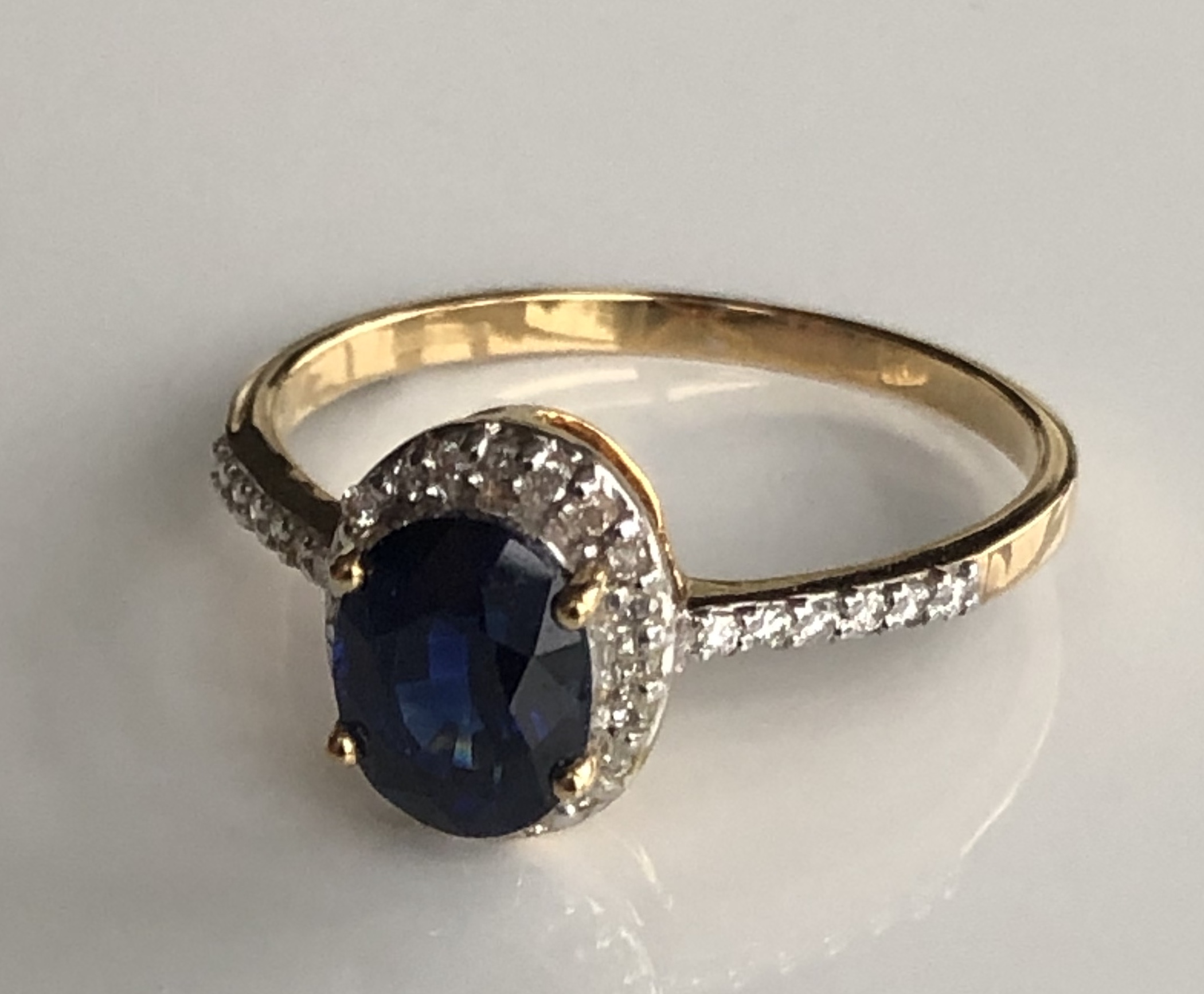 AN 18CT GOLD, CEYLON SAPPHIRE AND DIAMOND RING The Ceylon sapphire surrounded by diamonds.