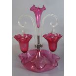 A VICTORIAN CRANBERRY GLASS EPERGNE Having a central tulip form glass flute, flanked by clear