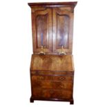 AN 18TH CENTURY WALNUT AND FEATHER BANDED BUREAU BOOKCASE The moulded cornice over a pair of fielded