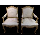 A FINE PAIR OF EARLY 19TH CENTURY ENGLISH GILTWOOD FRAMED OPEN ARMCHAIRS Carved with shells and