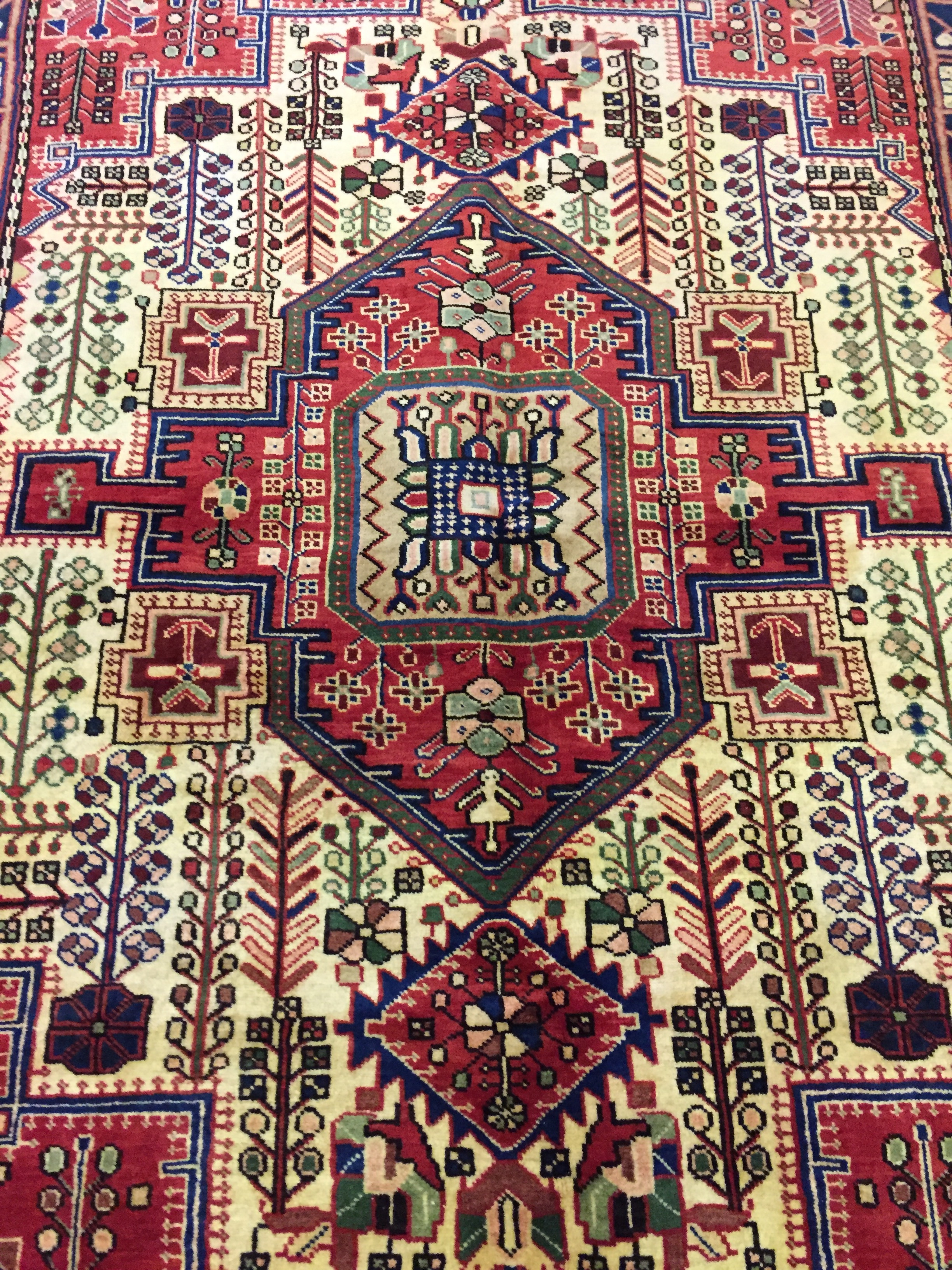 A PERSIAN WOOLEN NAHAVAND RUG The pendant medallion flanked by geometric and foliate motifs,