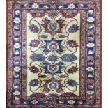 A PERSIAN WOOLLEN RUG Having floral decoration to central cream field, within a red and blue running