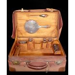 AN EARLY 20TH CENTURY SILVER FITTED AND LEATHER GENTLEMAN'S TRAVEL CASE Comprising a hand mirror,