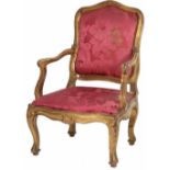 AN EARLY 18TH CENTURY ITALIAN WALNUT CARVED GILTWOOD OPEN ARMCHAIR The shaped carved back over