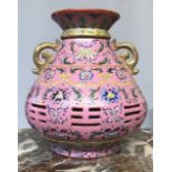 A CHINESE VASE WITH INTEGRAL LINER The pierced body decorated with floral sprays on a pink
