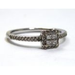 A 18CT WHITE GOLD AND DIAMOND RING Having four Princess cut diamonds edged with round cut diamonds