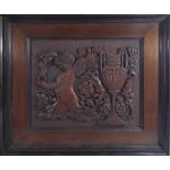 A PAIR OF CARVED WALNUT RELIEF PANELS Mirrored images of cherubs amongst foliage and a large urn,