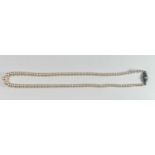 AN ART DECO PERIOD PEARL NECKLACE Having graduated pearls and a silver clasp set with single