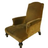 A VICTORIAN EASY ARMCHAIR In mustard velvet upholstery, on ebonised and gilt fluted legs.