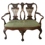 A 19TH CENTURY IRISH MAHOGANY TWO SEAT CHAIR BACK SETTEE The pierced vase splat backs centred with a