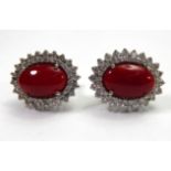 A PAIR OF 18CT WHITE GOLD EARRINGS Set with cabochon red coral surrounded by two rows of diamonds.