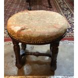 A VICTORIAN MAHOGANY OVAL STOOL With overstuffed upholstered seat, on turned legs joined by a ‘H’