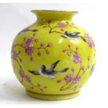 A CHINESE BULBOUS VASE Decorated with birds and flowers, on a yellow ground, bearing a four