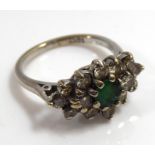 AN 18CT WHITE GOLD RING Set with a central emerald surrounded by a cluster of diamonds (size M/N).