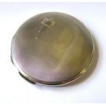 AN ART DECO SILVER CIRCULAR COMPACT With engine turned decoration, geometric initials cartouche