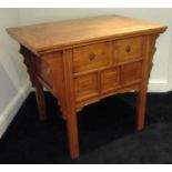 A 19TH CENTURY CHINESE ELM SIDE TABLE of Ming design with two drawers above a panels and shaped