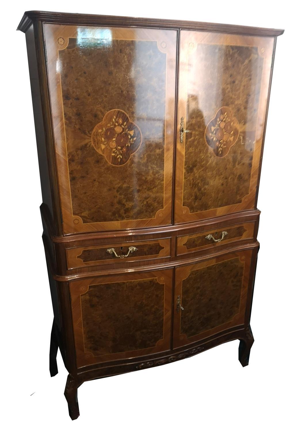 AN ITALIAN WALNUT AND FLORAL INLAID DRINK’S CABINET With two four doors and central drawers. (86cm x
