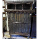 AN INDIAN HARDWOOD AND IRON BOUND SIDE CABINET With open shelves above cupboards on bun feet. (111cm