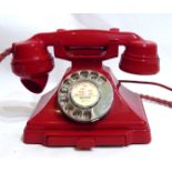 A VINTAGE RED BAKELITE TELEPHONE With chrome dial.