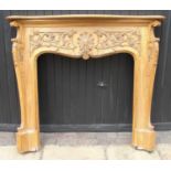 A CARVED WALNUT FIRE SURROUND The serpentine mantel above a ‘C’ scroll decorated frieze and acanthus
