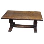 A SOLID OAK COFFEE TABLE The 3cm thick rectangular top, raised on two columns joined by a stretcher.