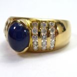 AN 18CT GOLD RING Set with a cabochon sapphire, with diamond encrusted shoulders.