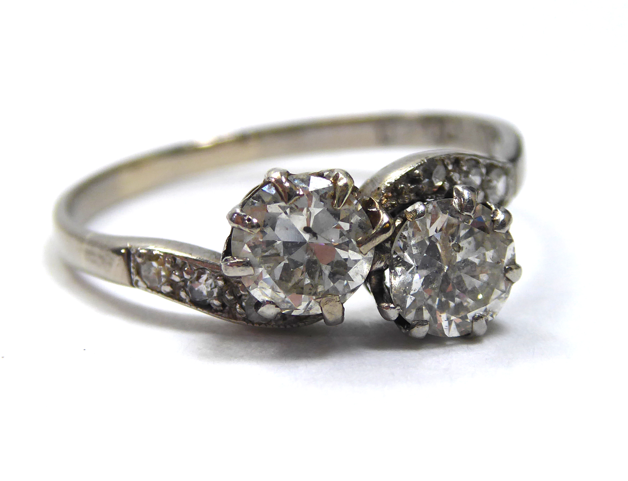 AN EARLY 20TH CENTURY 18CT WHITE GOLD AND DIAMOND TWIST RING Two round cut diamonds set in a half