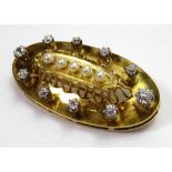 A YELLOW METAL OVAL BROOCH Set with a row of five pearls surrounded by diamonds.