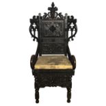 AN ANTIQUE OAK ARMCHAIR Crested with carved facial mask flanked by birds Gothic pierced wings