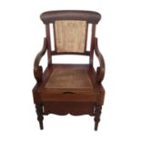 A LATE 19TH/EARLY 20TH CENTURY MAHOGANY COMMODE CHAIR With needlework backrest over scrolling open
