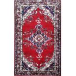 A TURKISH WOOLEN RUG With pendant medallion and floral motifs, within three running borders. (