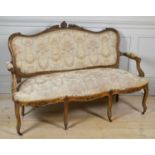A LATE 19TH/20TH CENTURY FRENCH WALNUT FRAMED SETTEE The scrolling padded back above a serpentine