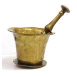 AN 18th CENTURY BRASS PESTLE AND MORTARhand beaten bell form mortar with tapered brass pestle Approx