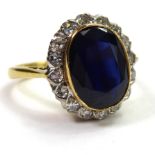 AN 18CT GOLD RING SET WITH AN OVAL SAPPHIRE Surrounded by diamonds.