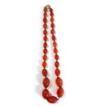 A VINTAGE CARNELIAN NECKLACE The single strand of graduating oval beads on a gilt metal clasp. (