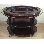 A VICTORIAN STYLE MAHOGANY OVAL DRINK?S TROLLEY With brass rail handles and bandings. (113cm x