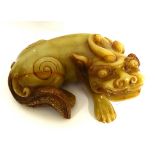 A 20TH CENTURY CARVED SOAPSTONE FIGURAL CARVING OF A DRAGON In recumbent pose, with engraved