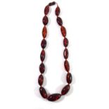 AN AMBER BEAD NECKLACE Having oval form graduating beads. (approx 24cm)