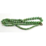 A VINTAGE CHINESE JADE NECKLACE Having a single strand of graduating spherical beads , with a yellow